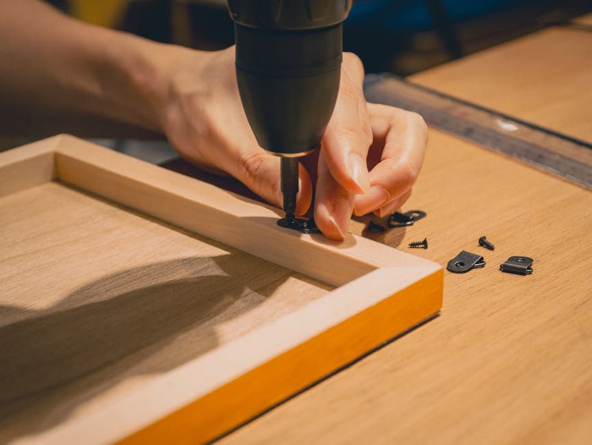 Hands carefully mounting a laser cut metal welcome sign onto a wooden wall using a drill and screws.